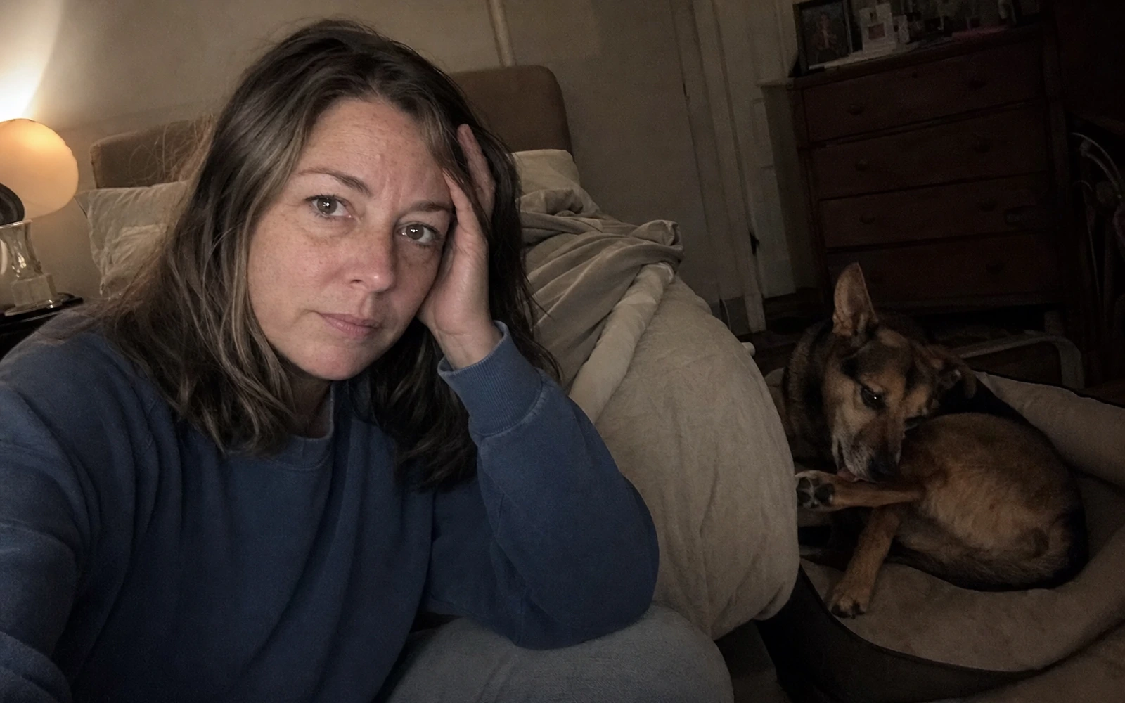 An owner lying awake at night while her dog licks and chews at her leg